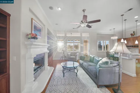 a living room with fireplace furniture and a view of kitchen