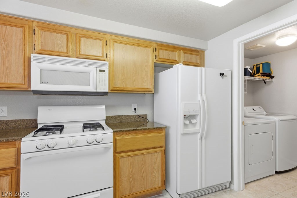 10550 West Alexander Road, Unit 2133 Las Vegas, NV 89129 - Photo 34 of 42 This bright kitchen features ample cabinetry, essential appliances, and an adjacent laundry area.