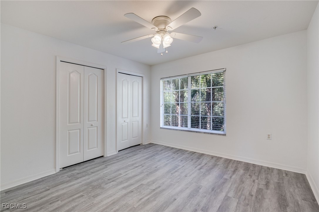 9470 Ivy Brook Run, Unit 805 Fort Myers, FL 33913 - Photo 13 of 31 a view of an empty room with a window and wooden floor