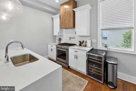 a kitchen with a sink a counter top space and living room area