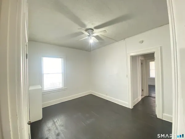 an empty room with a window and wooden floor