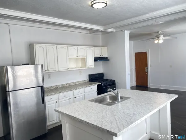 a kitchen with stainless steel appliances granite countertop a sink refrigerator and microwave