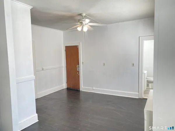 a view of an empty room with wooden floor