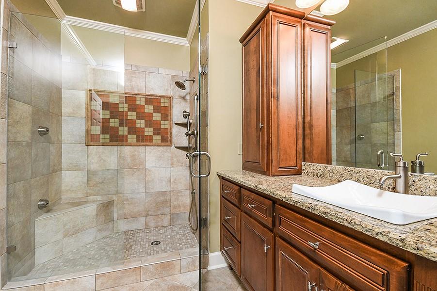 2865 Lenox Road Northeast, Unit 407 Atlanta, GA 30324 - Photo 22 of 27 a bathroom with a granite countertop sink a mirror and shower