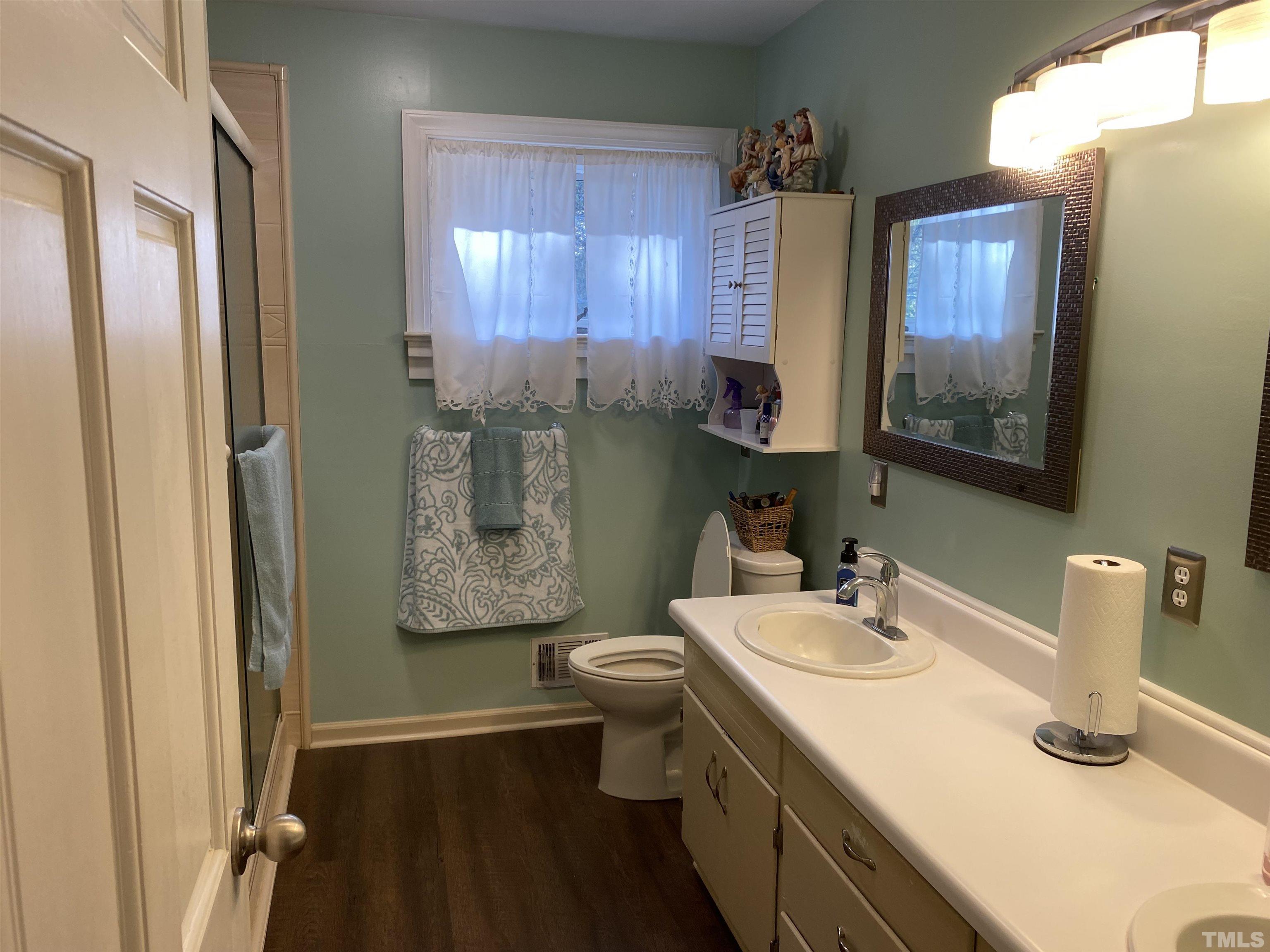 402 Stallings Road Zebulon, NC 27597 - Photo 3 of 14 a bathroom with a sink toilet and mirror