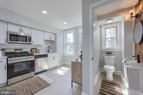 a view of a kitchen with a sink wooden cabinets and stainless steel appliances