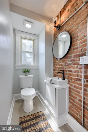 a bathroom with a toilet a sink and a mirror