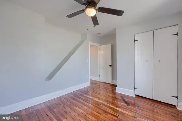 a view of an empty room with wooden floor