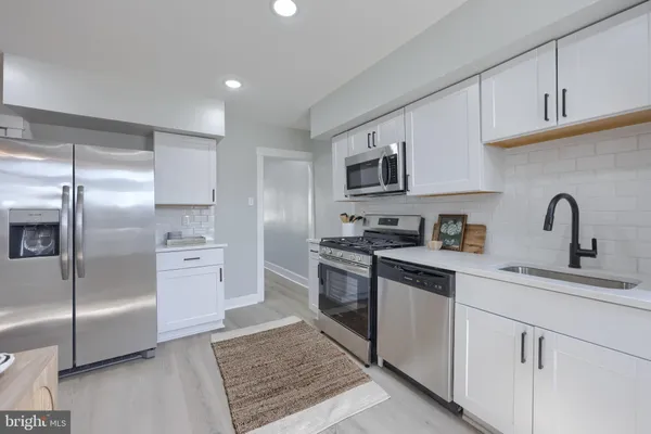 a kitchen with stainless steel appliances granite countertop a refrigerator sink and stove