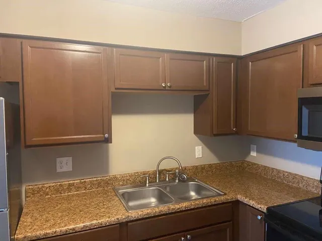 a kitchen with granite countertop a sink and cabinets