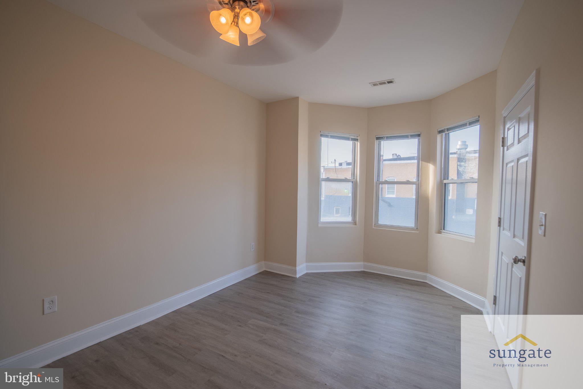4032 Falls Road, Unit 2 Baltimore, MD 21211 - Photo 13 of 30 an empty room with wooden floor and windows