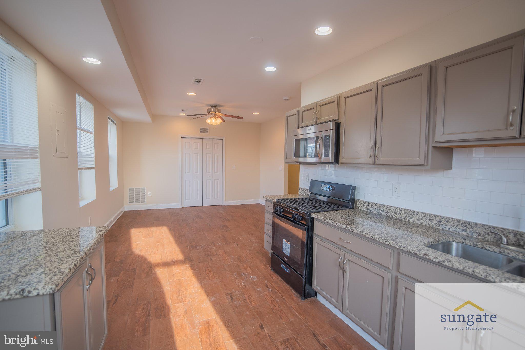 4032 Falls Road, Unit 2 Baltimore, MD 21211 - Photo 2 of 30 a kitchen with stainless steel appliances granite countertop a sink stove and cabinets