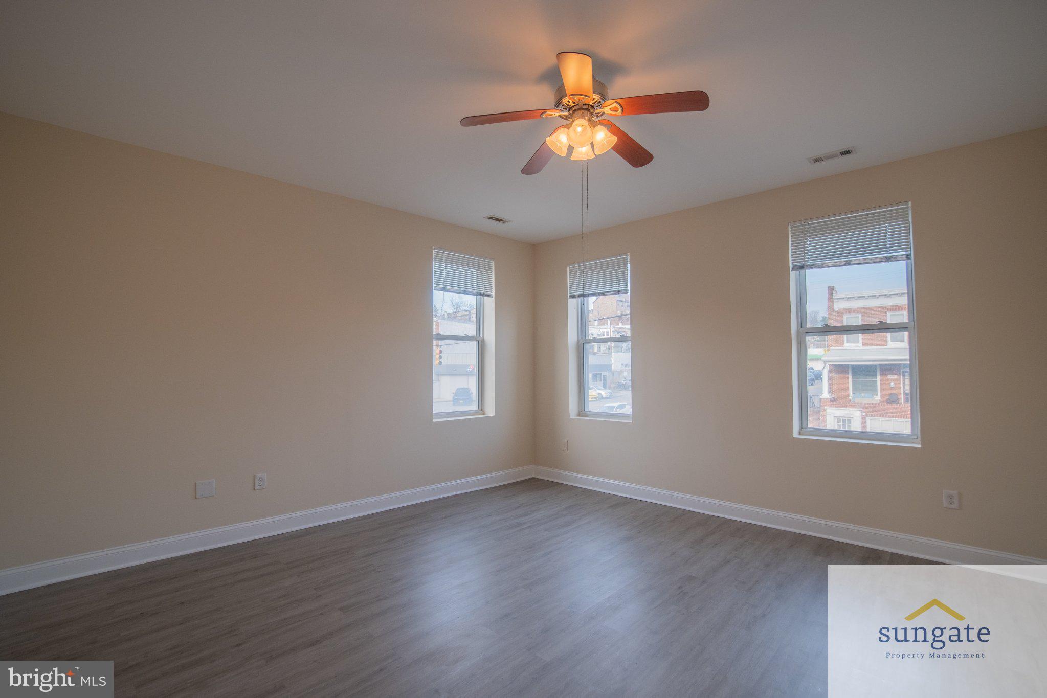 4032 Falls Road, Unit 2 Baltimore, MD 21211 - Photo 21 of 30 a view of a livingroom with a fan a large window and wooden floor