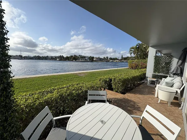 a view of a chairs and table in patio with lake view