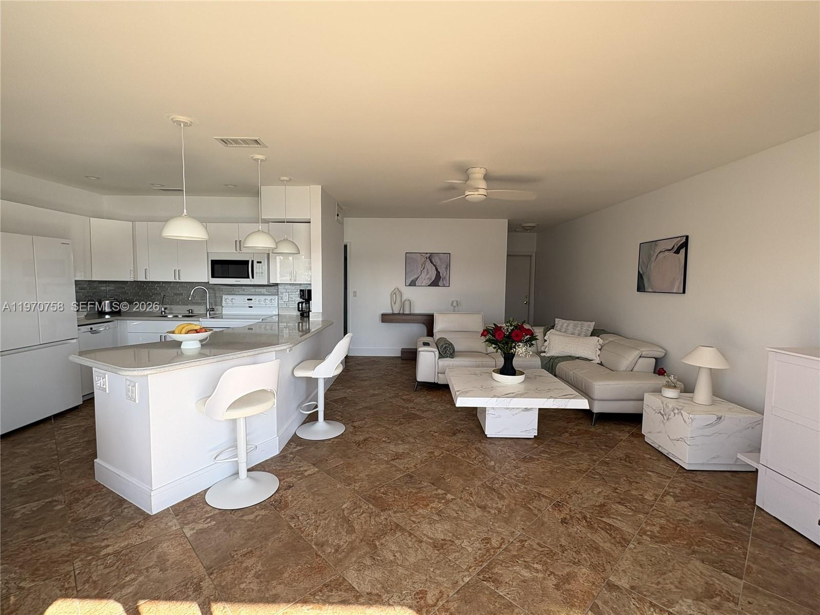 1201 South Riverside Drive, Unit 107 Pompano Beach, FL 33062 - Photo 12 of 27 a room with white cabinets and couches