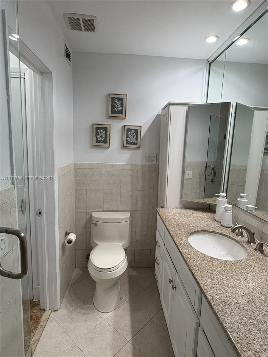1201 South Riverside Drive, Unit 107 Pompano Beach, FL 33062 - Photo 17 of 27 a spacious bathroom with a granite countertop sink toilet and shower