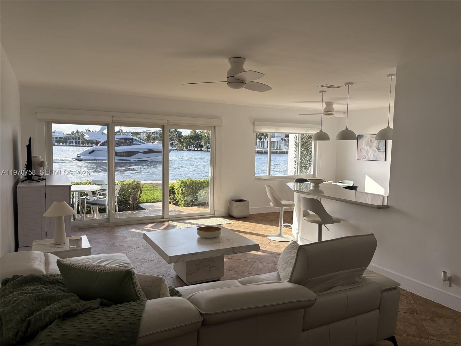 1201 South Riverside Drive, Unit 107 Pompano Beach, FL 33062 - Photo 3 of 27 a living room with furniture and a large window