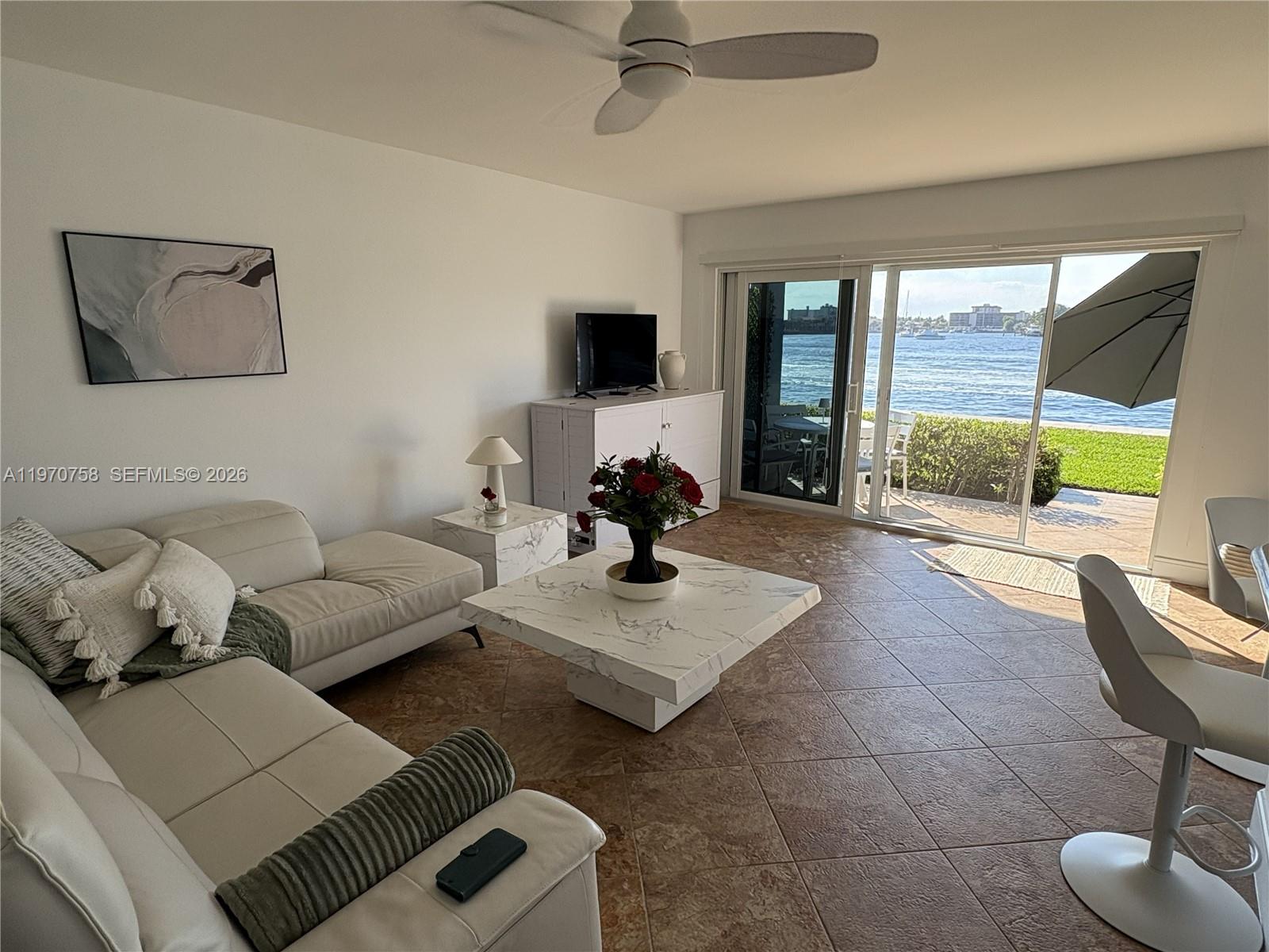 1201 South Riverside Drive, Unit 107 Pompano Beach, FL 33062 - Photo 4 of 27 a living room with furniture and a floor to ceiling window