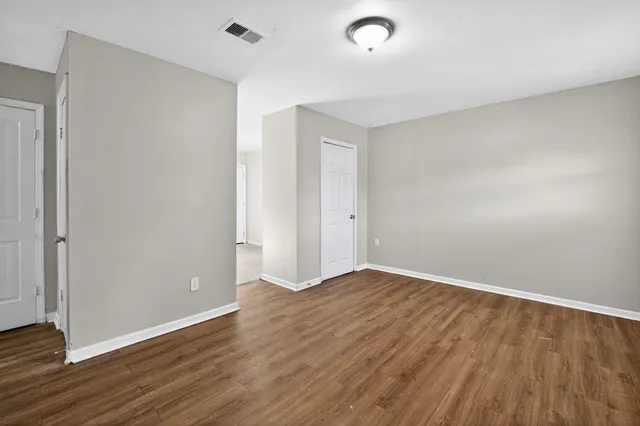 a view of an empty room with wooden floor