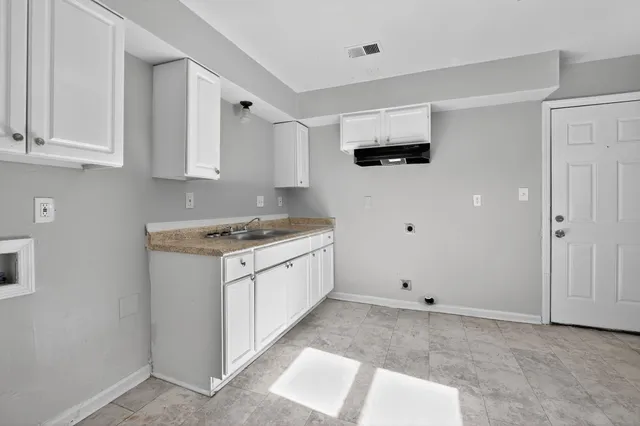 a view of a kitchen with sink cabinet and refrigerator