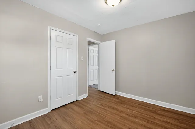 a view of an empty room with wooden floor