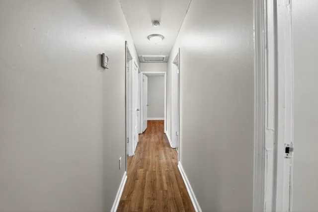 a view of a hallway with wooden floor