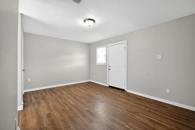 a view of an empty room with wooden floor
