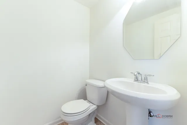 a bathroom with a sink a toilet and mirror
