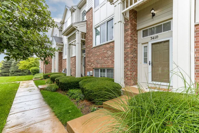 a view of a brick house with a yard and plants