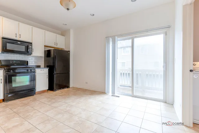 a view of a kitchen with an empty space and a refrigerator