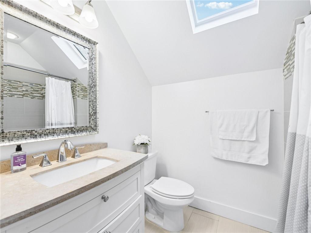 1399 North Druid Hills Road Northeast Atlanta, GA 30319 - Photo 38 of 58 a bathroom with a granite countertop sink a toilet and a mirror