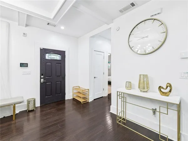 a dining room with wooden floor a chandelier a wooden table and chairs