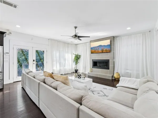 a living room with furniture kitchen view and a flat screen tv