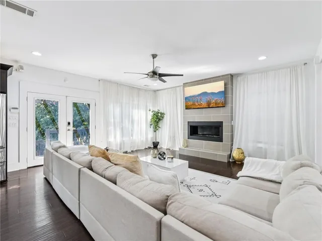 a living room with furniture kitchen view and a flat screen tv