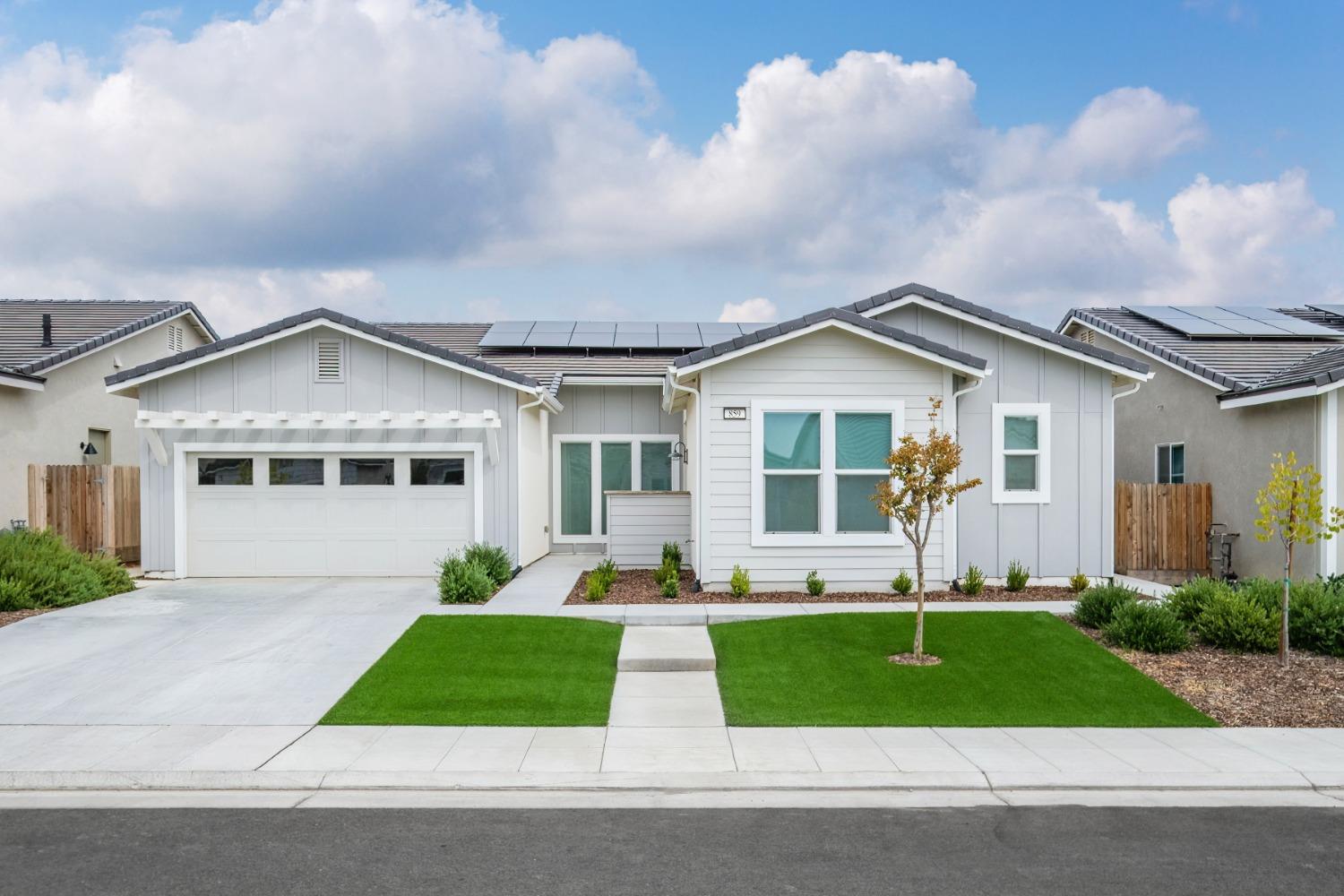a front view of a house with a garden and plants