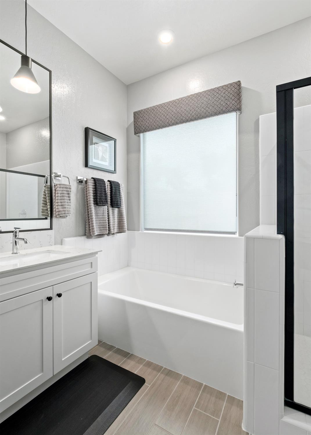 859 Maclure Avenue Madera, CA 93636 - Photo 24 of 53 a bathroom with a bathtub a shower a sink and a window