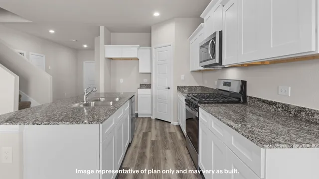 a kitchen with stainless steel appliances granite countertop a sink stove and cabinets