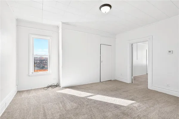 an empty room with closet and windows