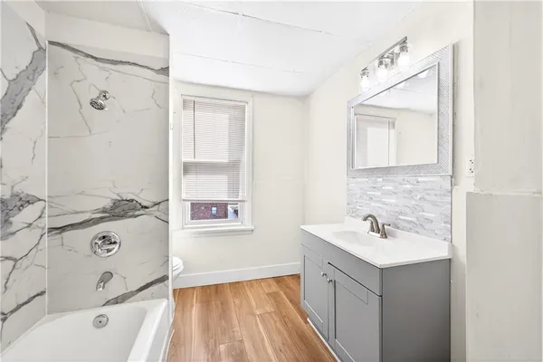 a bathroom with a tub sink and mirror