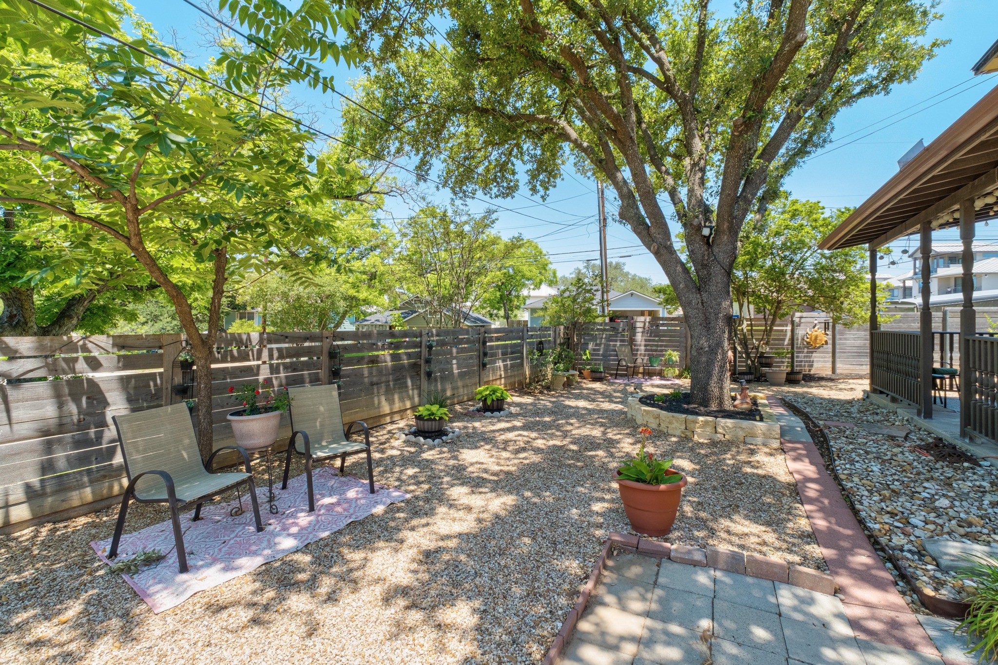 1184 Waller Street Austin, TX 78702 - Photo 17 of 19 a view of a backyard with table and chairs potted plants and large tree