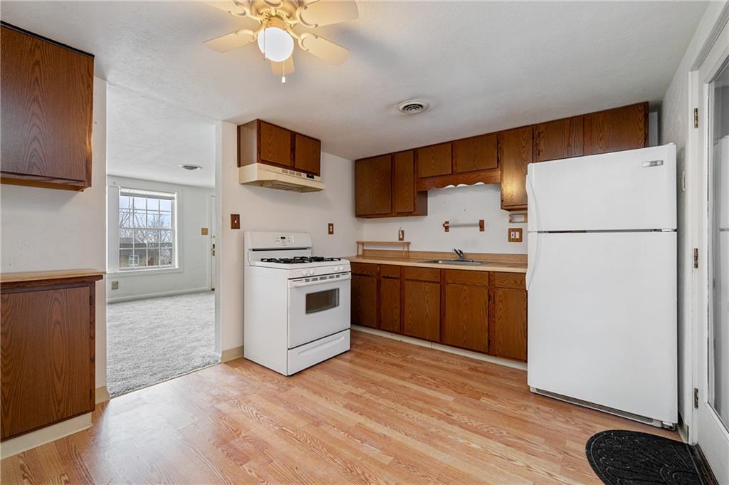 3504 Bevan Road North Versailles, PA 15137 - Photo 14 of 21 a kitchen with a refrigerator sink and white cabinets