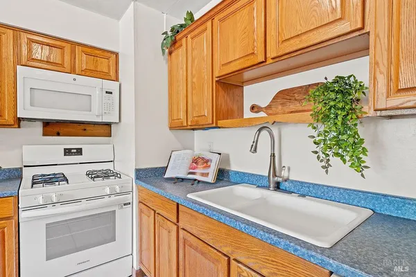 a kitchen with stainless steel appliances granite countertop a sink stove and cabinets