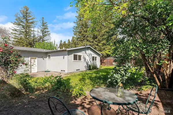 a backyard of a house with table and chairs