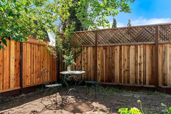 a backyard of a house with lawn chairs and wooden fence
