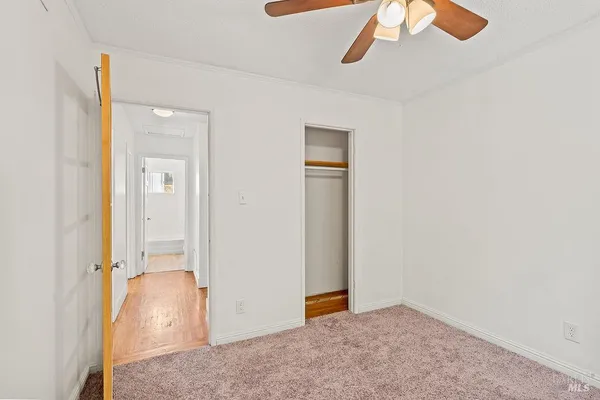 an empty room with a window and a ceiling fan