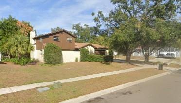 front view of a house with a yard and trees