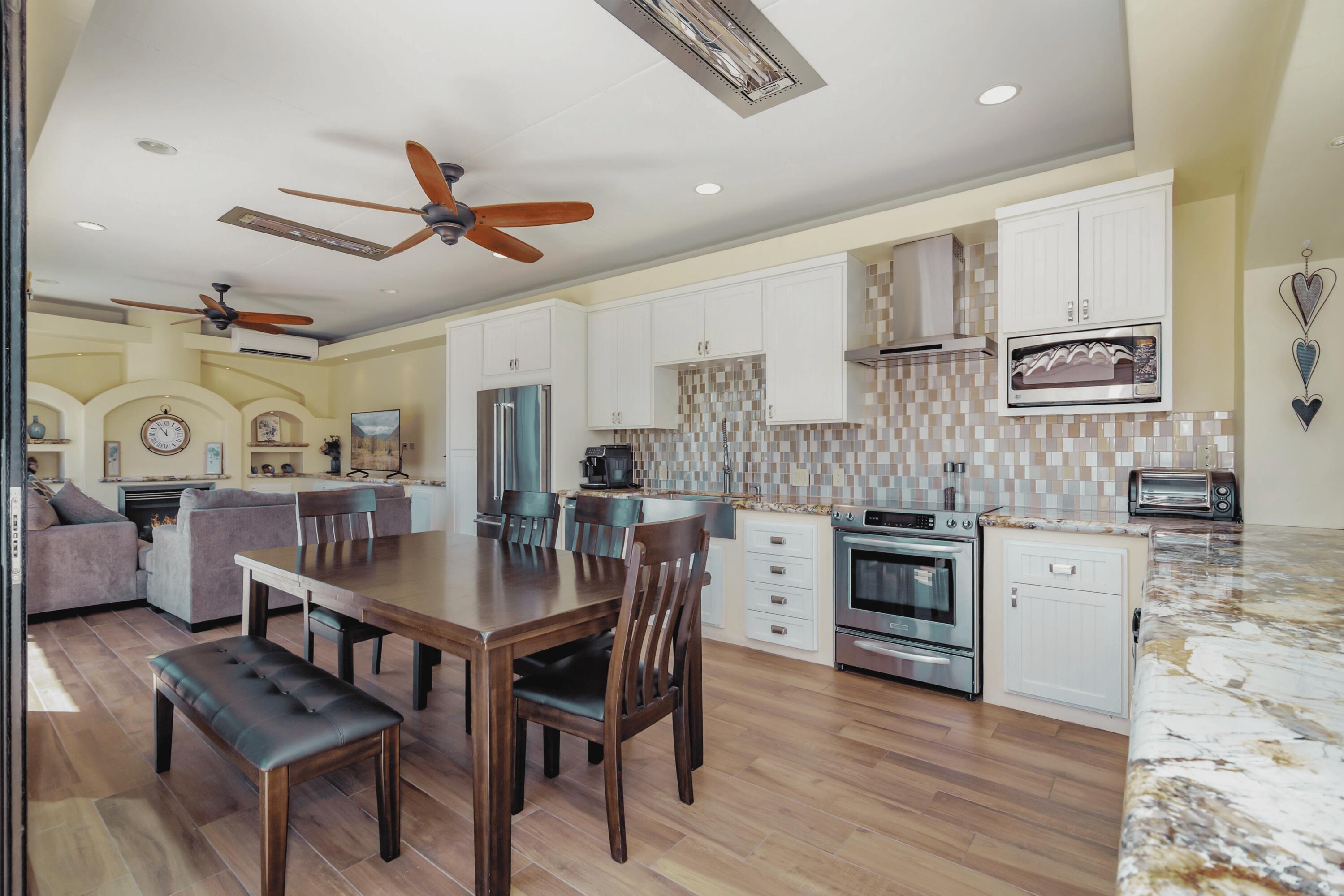 80501 Ave 48, Unit 21 Indio, CA 92201 - Photo 14 of 32 a kitchen with stainless steel appliances kitchen island granite countertop a table chairs and a refrigerator