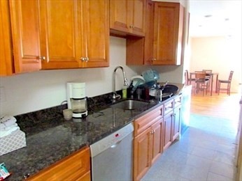 10 Moreland Street, Unit 2 Boston, MA 02119 - Photo 15 of 15 a kitchen with granite countertop a sink a stove and cabinets