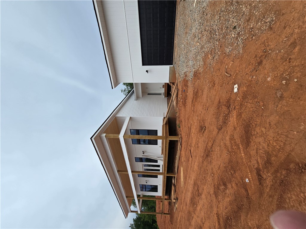 157 Hunting Hollow Road Six Mile, SC 29682 - Photo 6 of 19 A new construction home awaits finishing touches with a prominent garage and covered outdoor living space.