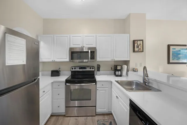 a kitchen with white cabinets and white appliances